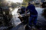 Daniel Stover, 17, moves a boat of personal belongings from a friend's flooded home in Sorrento, La. USA, Saturday, Aug. 20, 2016. The American Red Cross described the flood as {quote}the largest natural disaster to hit the United States since Superstorm Sandy.{quote} (AP Photo/Max Becherer)