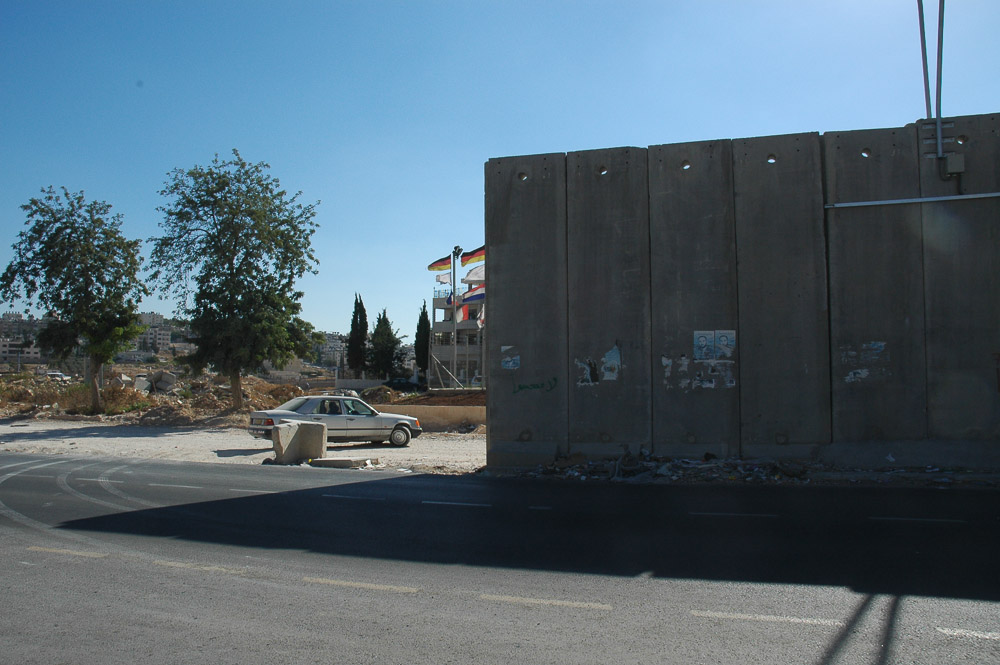A Ram, a Jerusalem suburb, is separated from Jerusalem by a 26 ft concrete wall. It snakes in and out separating houses, and families.