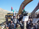 Women blocking the bulldozers from constructing the wall.