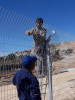 Migrant workers building the fence in Hebron