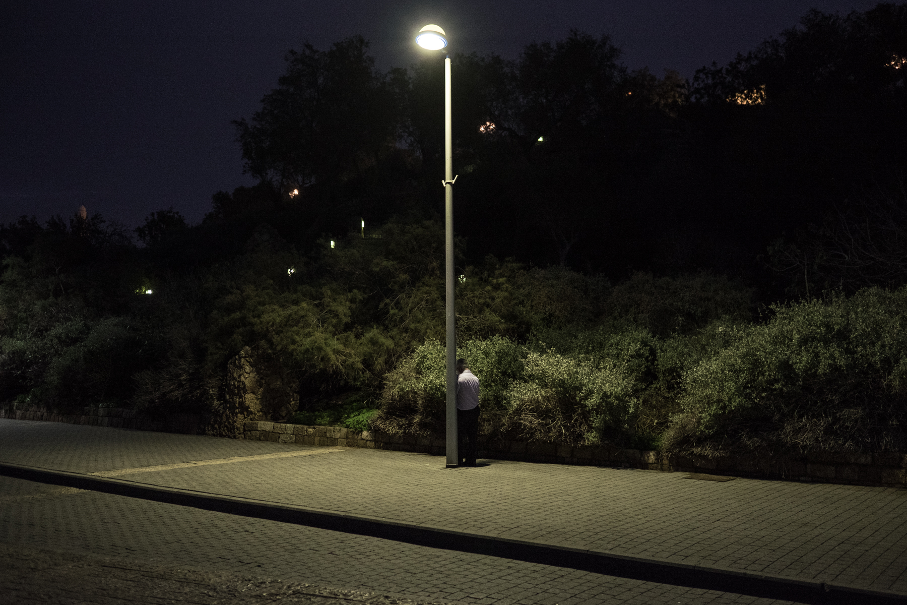 a jewish man praying next to a light post in Tel Aviv/Israel
