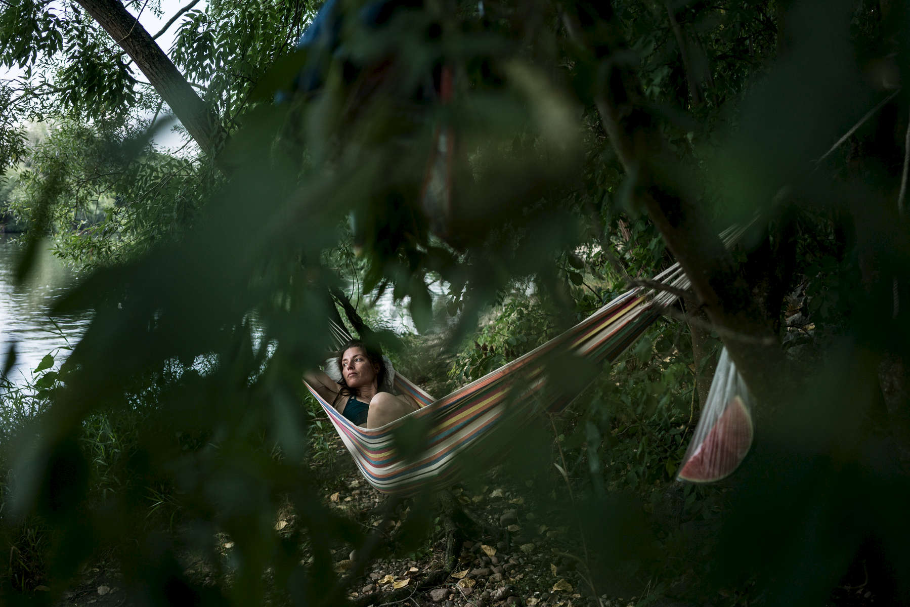 A woman in the German city of Offenbach is photographed while laying in a hammock on the riverside in Offenbach