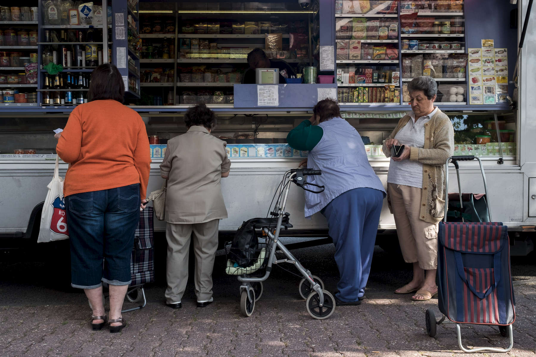 Women are buying groceries at a mobile market in Frankfurt's district Praunheim
