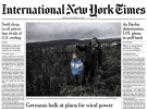 tearsheet of fronpage of International New York Times showing Harald Hossfeld with his son in a field in the state of Hesse in Germany. Hossfeld leads a protest movement against wind power in the area.