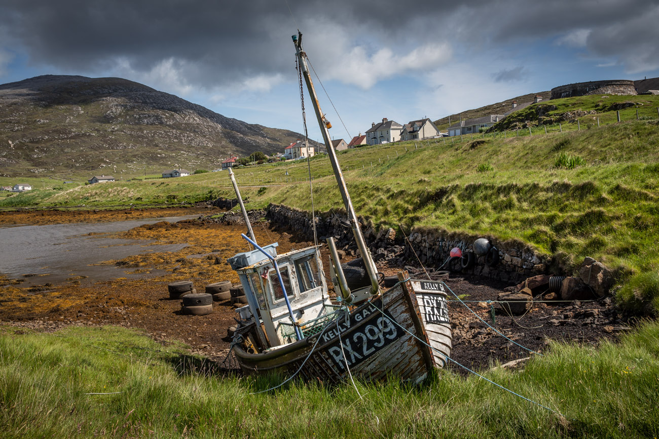 beautiful Old wooden boat at the shore at Leverburgh with mountains behind on a beautiful sunny day on the Isle of Harris