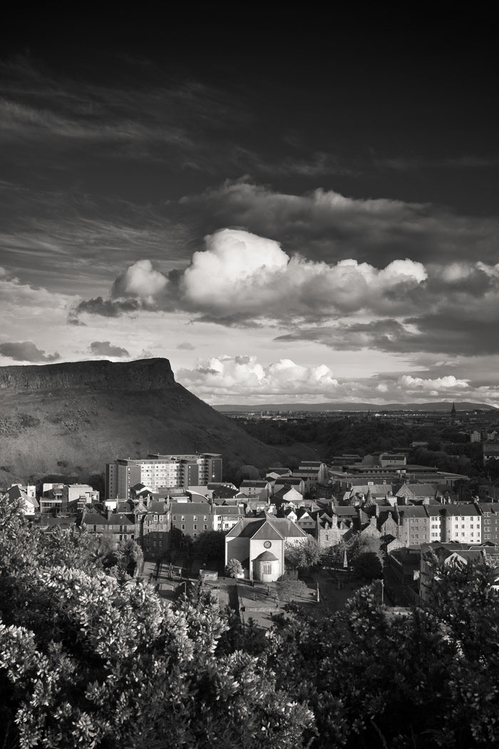  beautiful black and white view of Arthurs seat from Calton Hill, Edinburgh on a sunny day with a moody dark sky