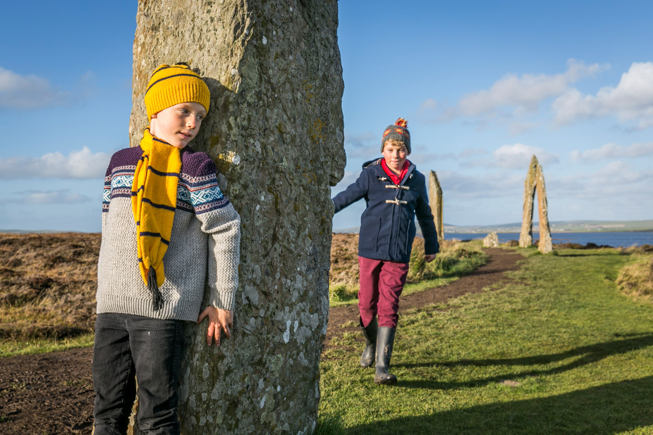 Historic Scotland  - child hiding behind a standing stone at the ring of Brodgar on Orkney