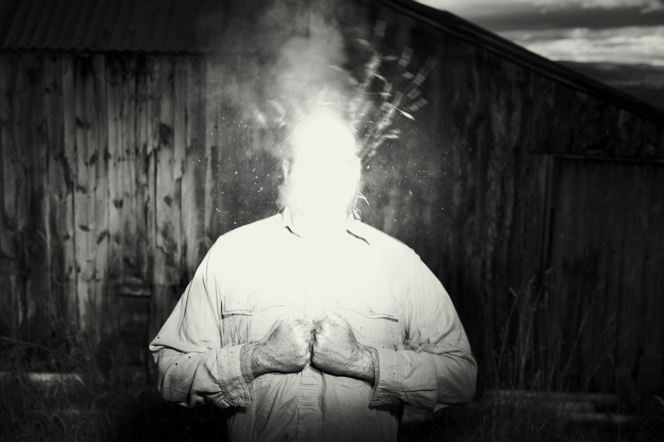 surreal photograph of a man with a bright lit smoking head