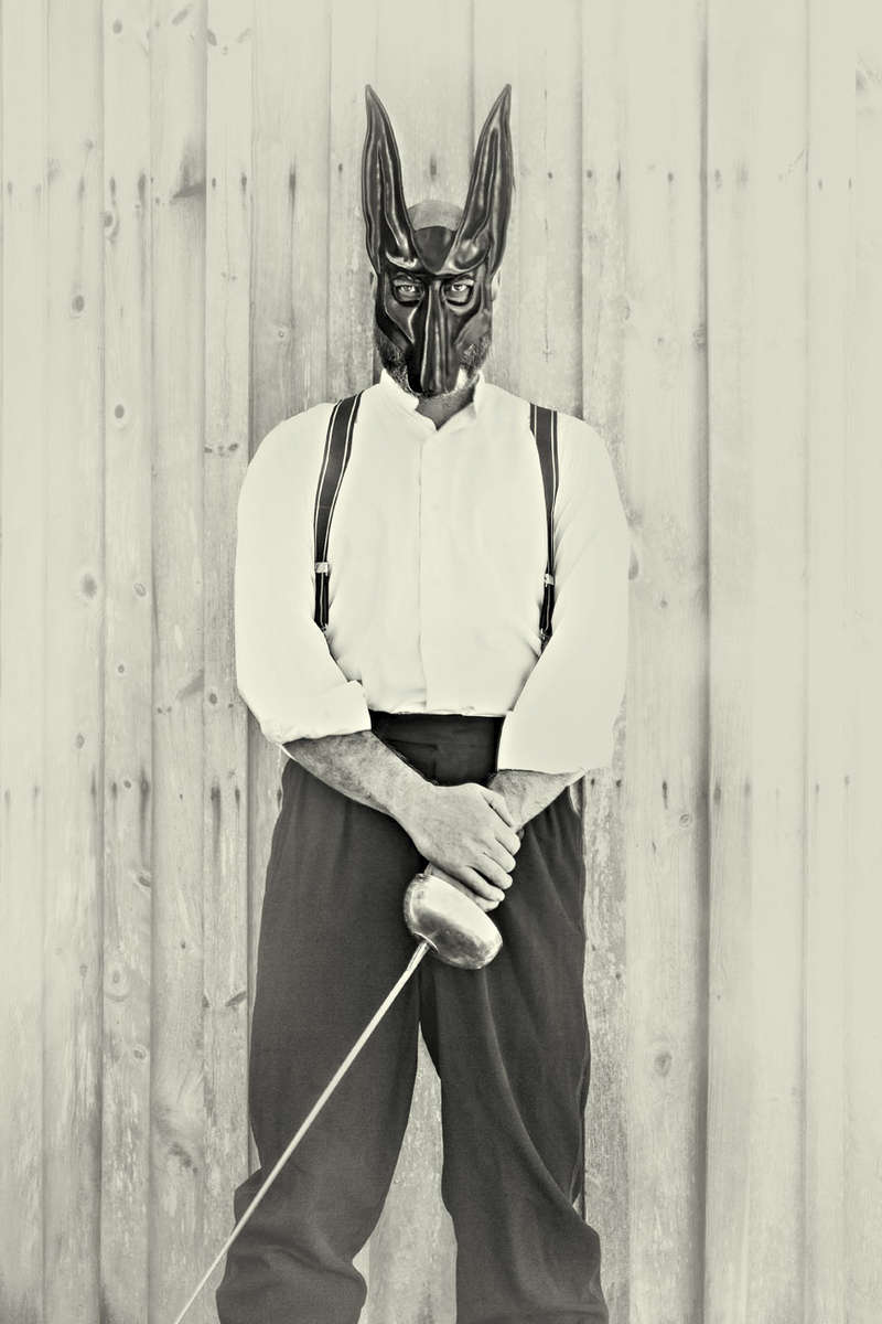 Man with a leather jackal mask and a sword