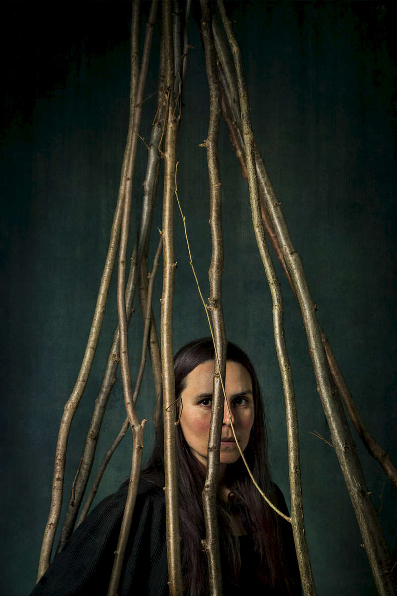 a portrait of a woman hemmed in by sticks