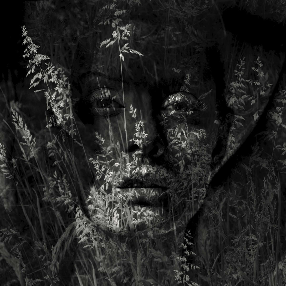 Double exposure nude portrait of a young woman with grasses
