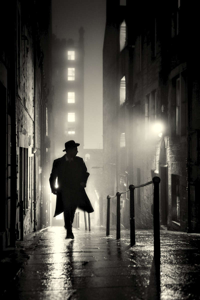 Dead of night noir portrait of a man in Edinburgh’s old town back streets. Third man style