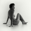 seated naked girl in a studio. Fine art beautiful nude