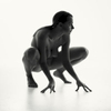 crouching nude woman sillhouetted in a white studio.