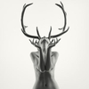 Double exposure nude of a woman with Antlers in black and white with head back and hands held up