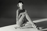 Nude of a beautiful seated woman with projected abstract stripes