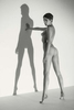Roarie Yum - nude woman with strong shadow against a wall