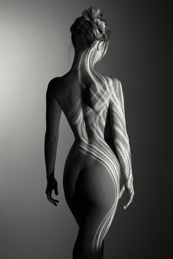 nude woman in studio with projector light