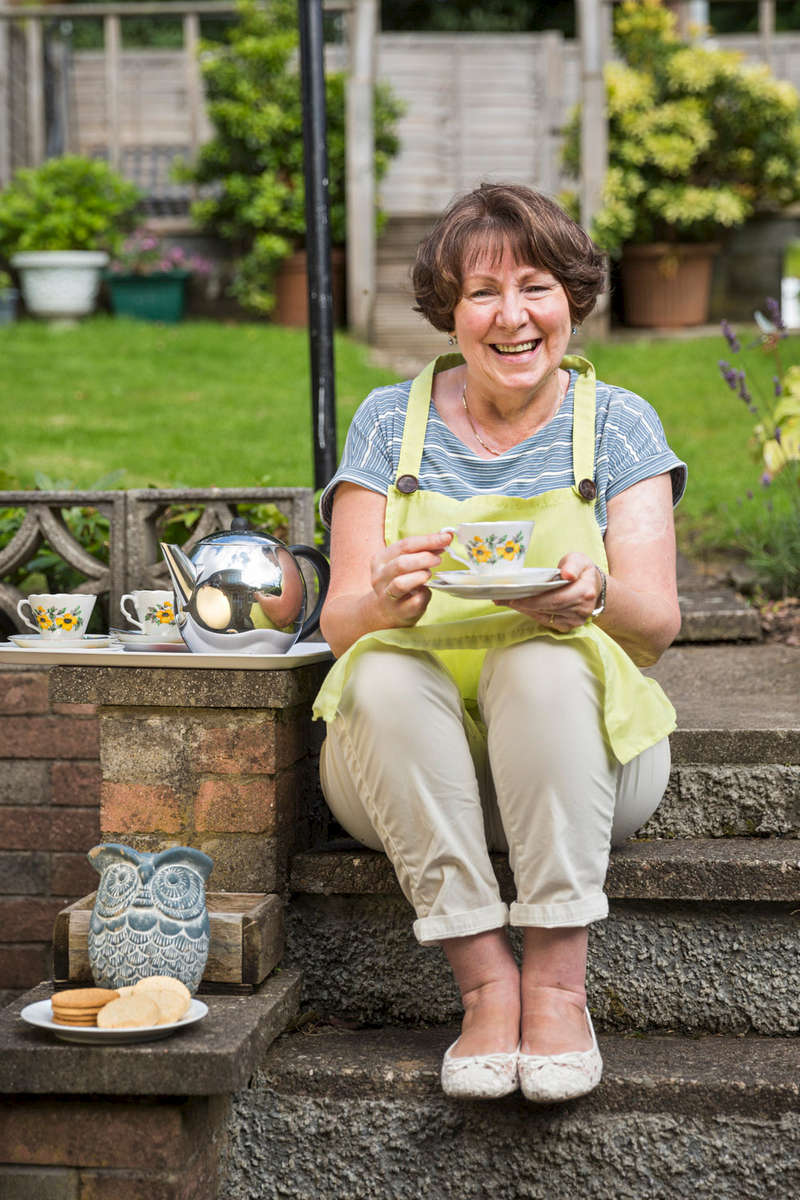 GRA_9792-woman-having-a-cup-of-tea-and-biscuit-outside