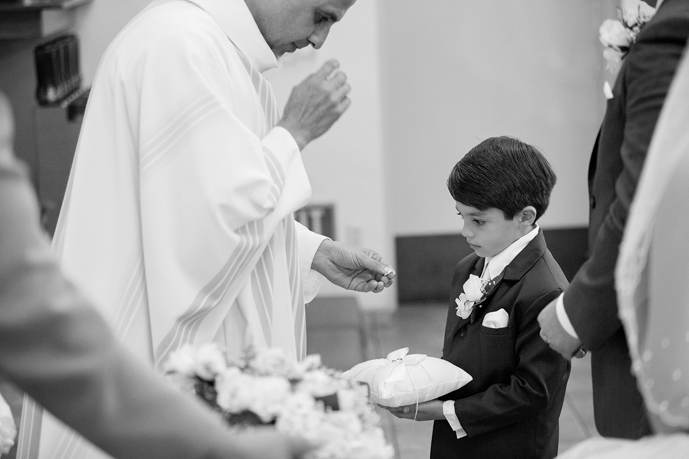 little boy usher looking at wedding ring 