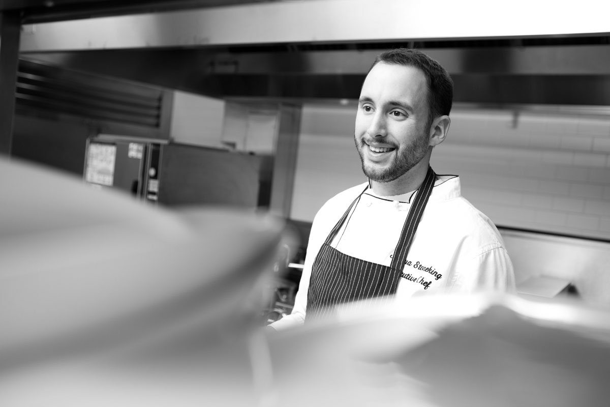 Black and white image of a chef working in a kitchen.