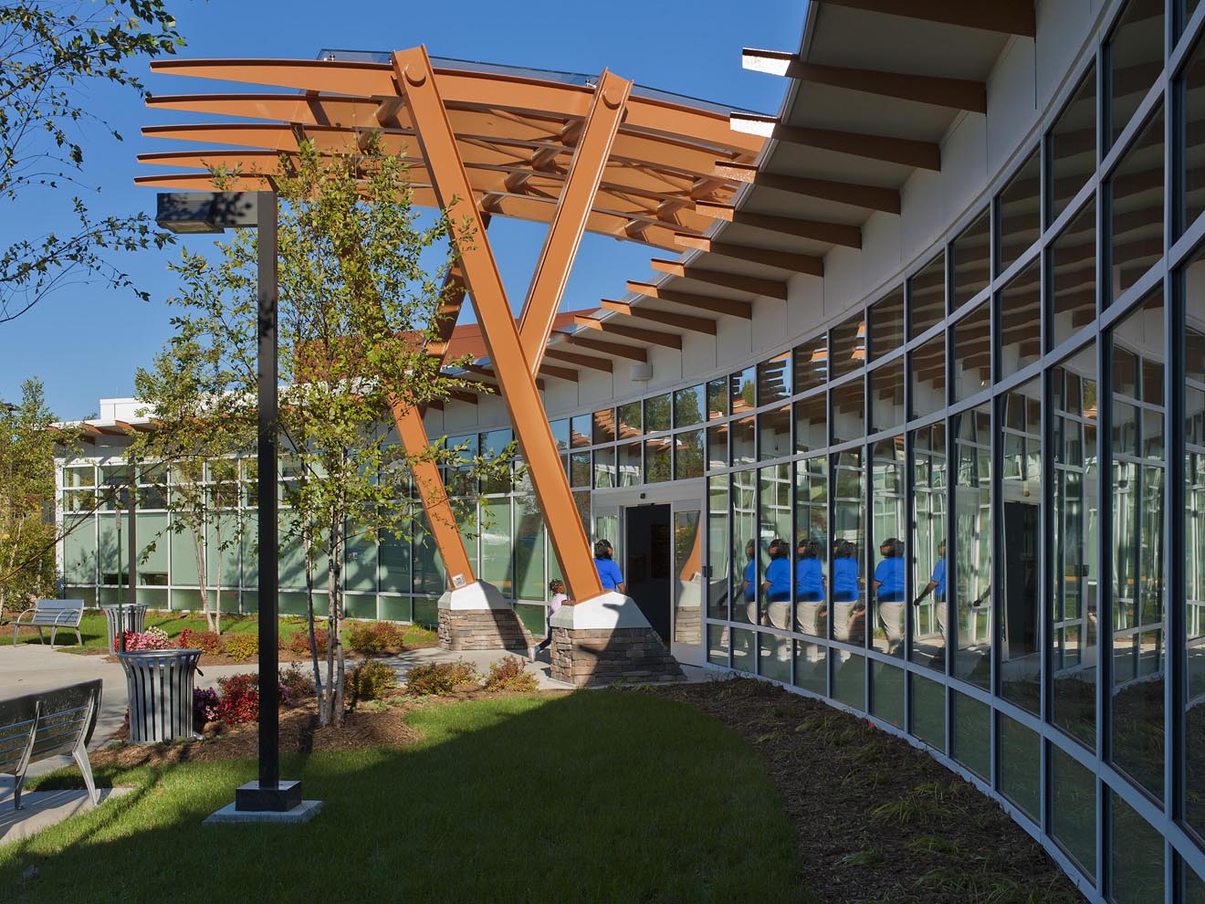 person entering library entrance under canopy during daytime