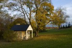 stone springhouse with fall foliage
