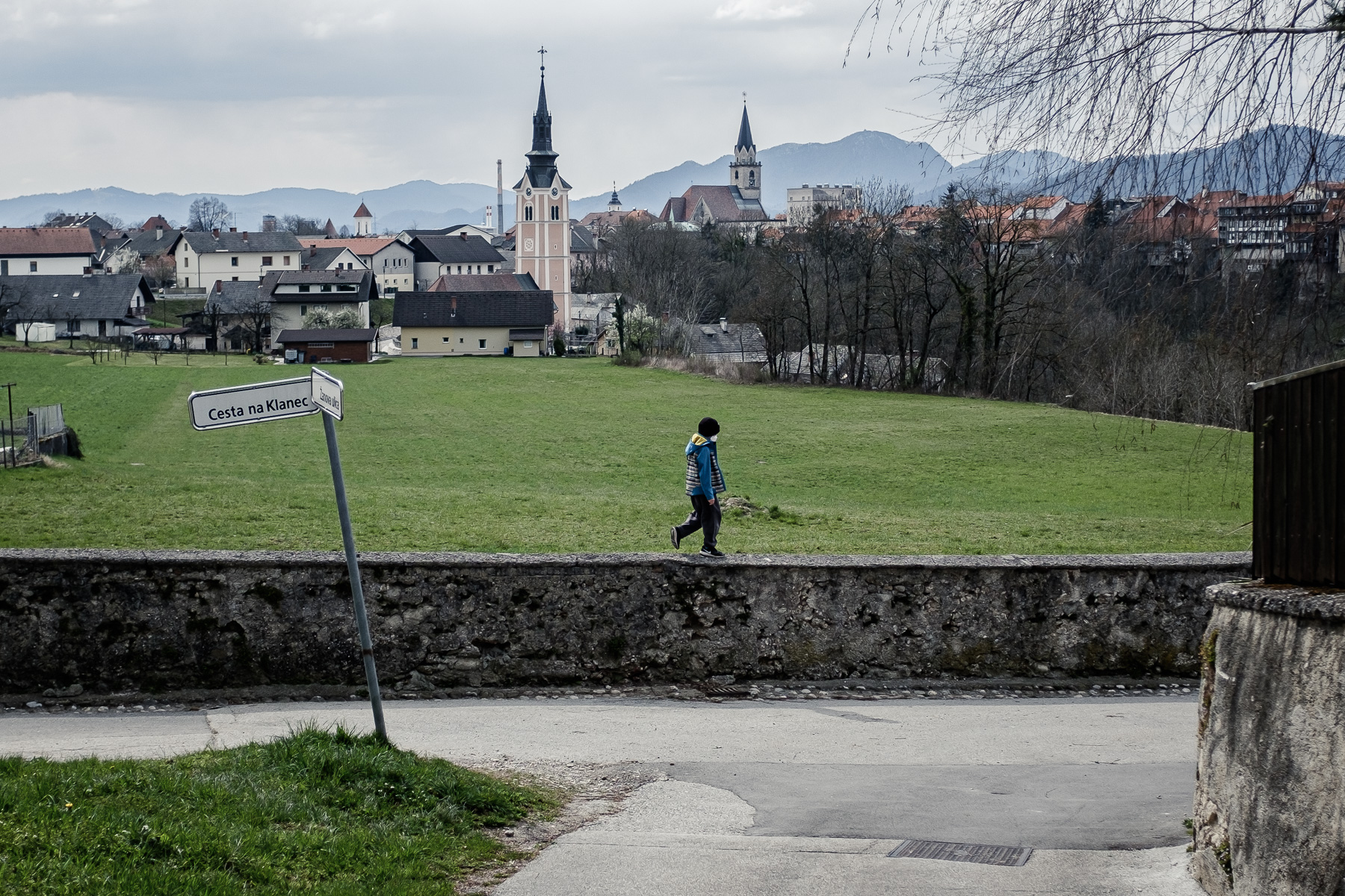 A boy wearing a protective mask walks on a stone wall in Kranj, Slovenia, during a nationwide coronavirus lockdown, on March 24, 2020.