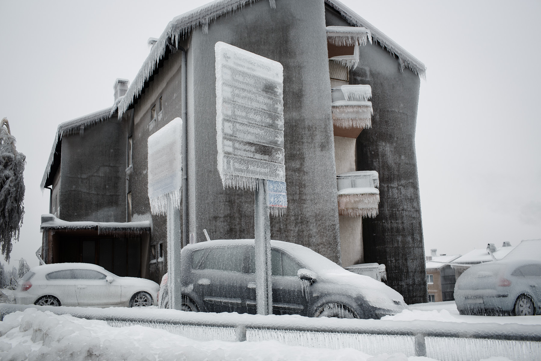 An apartment building, cars and signposts are seen covered in thick layer of ice in Postojna, Slovenia, February 5 2014.