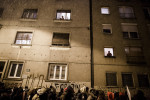Protesters march through the streets as people watch from their windows during anti-government protests in Ljubljana, Slovenia, on December 7, 2012.