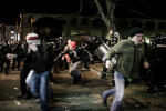 Protesters run as cobblestones and pyrotechnics start flying during protests against the mayor of Maribor Franc Kangler in Maribor, Slovenia, on December 3, 2012.