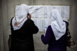 Bosnian women check the list of names of identified bodies in front of the Potocari memorial center, Srebrenica, July 10, 2010.