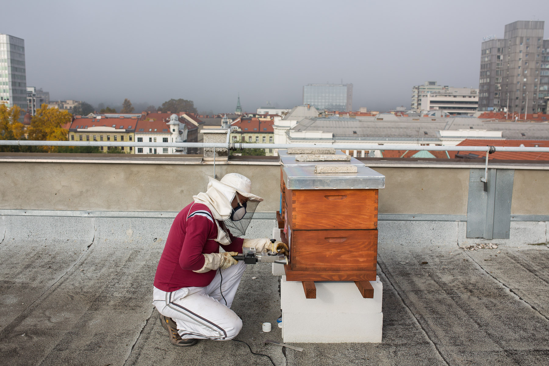 Nearing the end of the bee season, Trušnovec fights the spreading of varroa by administering oxalic acid via sublimator vaporizer on the rooftop of Radio Slovenia.