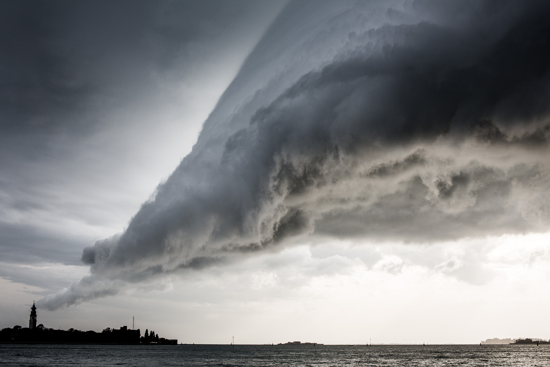 A storm cloud hangs above the San Servolo Island in central lagoon near the main island of Venice on September 26, 2012. Venice is subject to strong storms, Bora and scirocco winds that bring waves and high tides that eventually flood the city. Storms at sea and inland are especially dangerous. The open sea storms bring tides, while the inland storms bring flooding from rivers that flow into the lagoon.