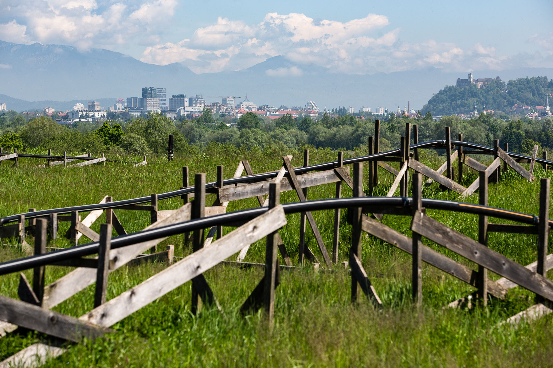 The city of Ljubljana is seen over the green hill of Ljubljana's old landfill and its methane gas pipes on May 10, 2019.