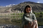 PHANDER, PAKISTAN - JULY 7: A Pakistani girl smiles against the mountainous landscape of Phander near the annual Shandur Polo Festival, July 7, 2007 on Shandur pass in Pakistan. The three day festival is the world's highest pitch at 3,810 meters surrounded by mountains from the Hindukush, Pamir and Karakoram ranges. The matches are played between the A, B, and C level teams from Gilgit and Chitral, traditional rival teams. It is believed that Polo was introduced in South Asia by the Muslim conquerors in the 13th century.  (Photo by Paula Bronstein/Getty Images)