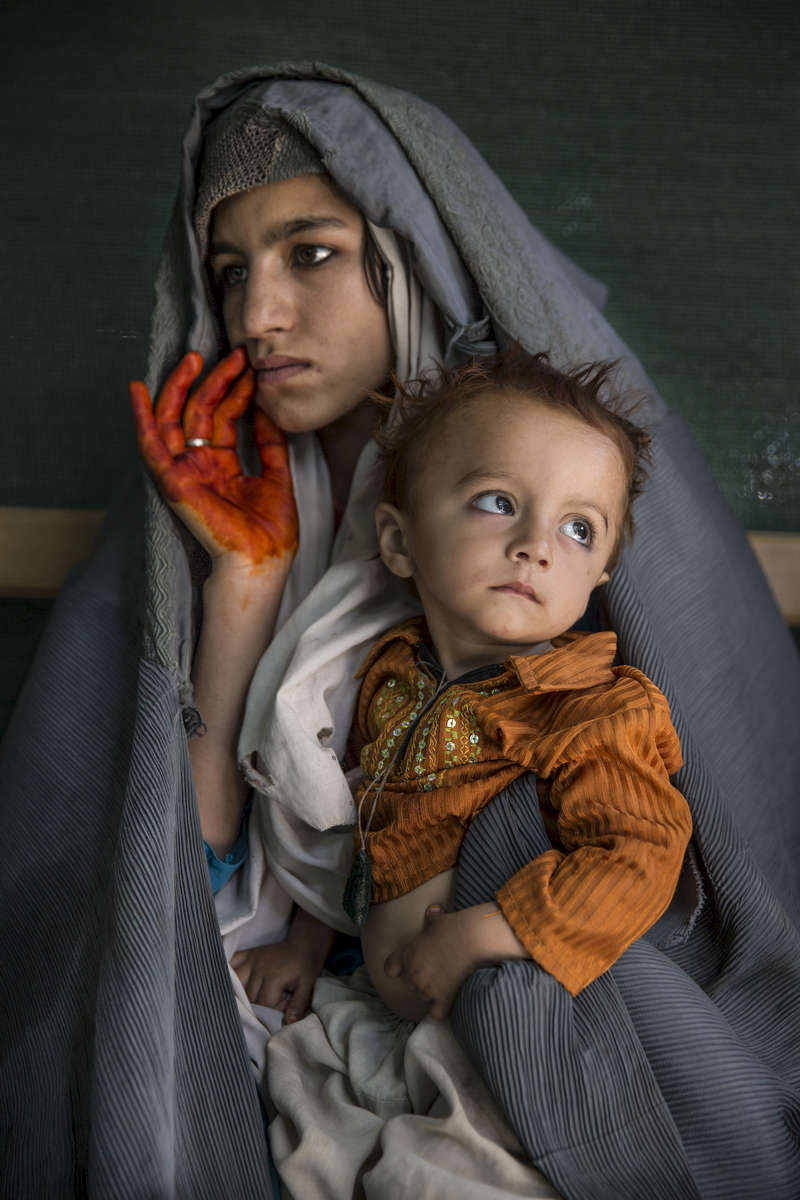 Razima holds her son, Malik 2 years old, waiting for medical attention at the Boost Hospital emergency room in Lashkah Gar, Afghanistan. Afghan hospitals like Boost, in the capital of war-torn Helmand province, have been registering significant increases in severe malnutrition amongst children. Countrywide, such cases have increased dramatically according to United Nations figures.