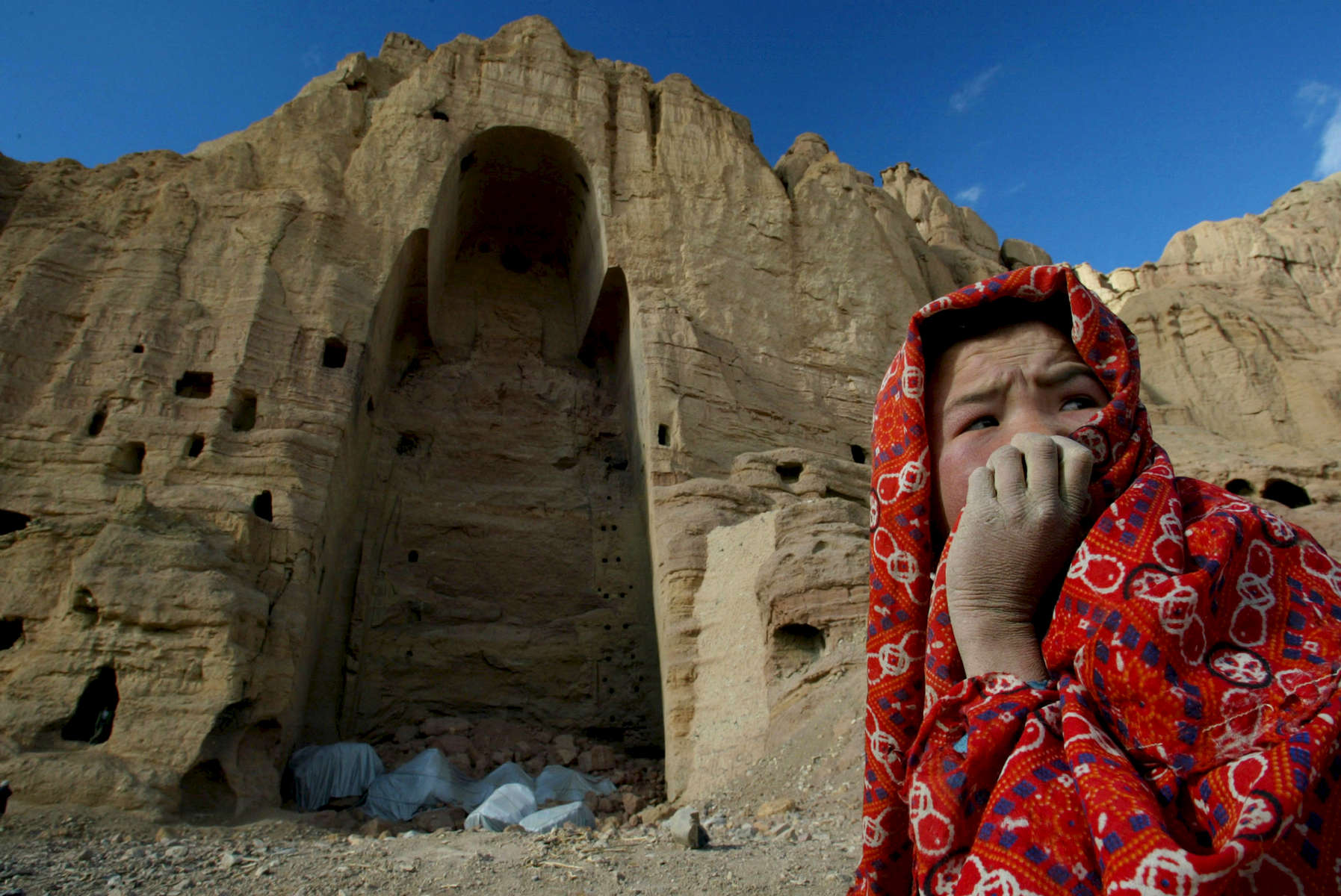 An Afghan girl who lives in the caves of Bamiyan, Afghanistan sits in front of the destroyed Buddha statue in Bamiyan, Afghanistan on February 19,2002. The ancient Buddhist statue was blown up by the Taliban in 2001. Buddha of Bamiyan,  230 km northwest of Kabul at an altitude of 2,500 meters.Paula Bronstein/Getty Images