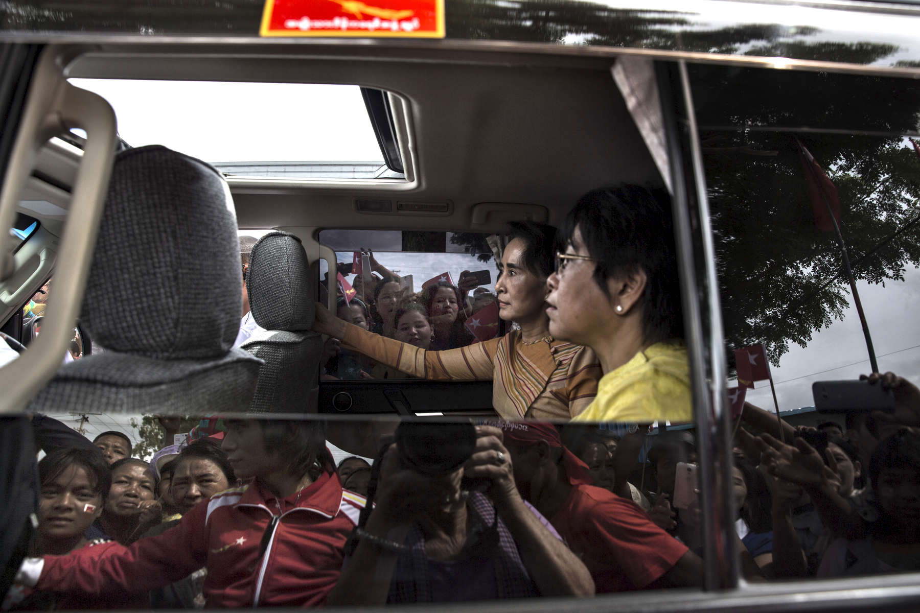 Seik Kaung:  Aung San Suu Kyi is seen in in her vehicle with her aide as supporters surround the car during an early election campaign visit to Shan state.Paula Bronstein for Der Spiegel / Getty Images Reportage