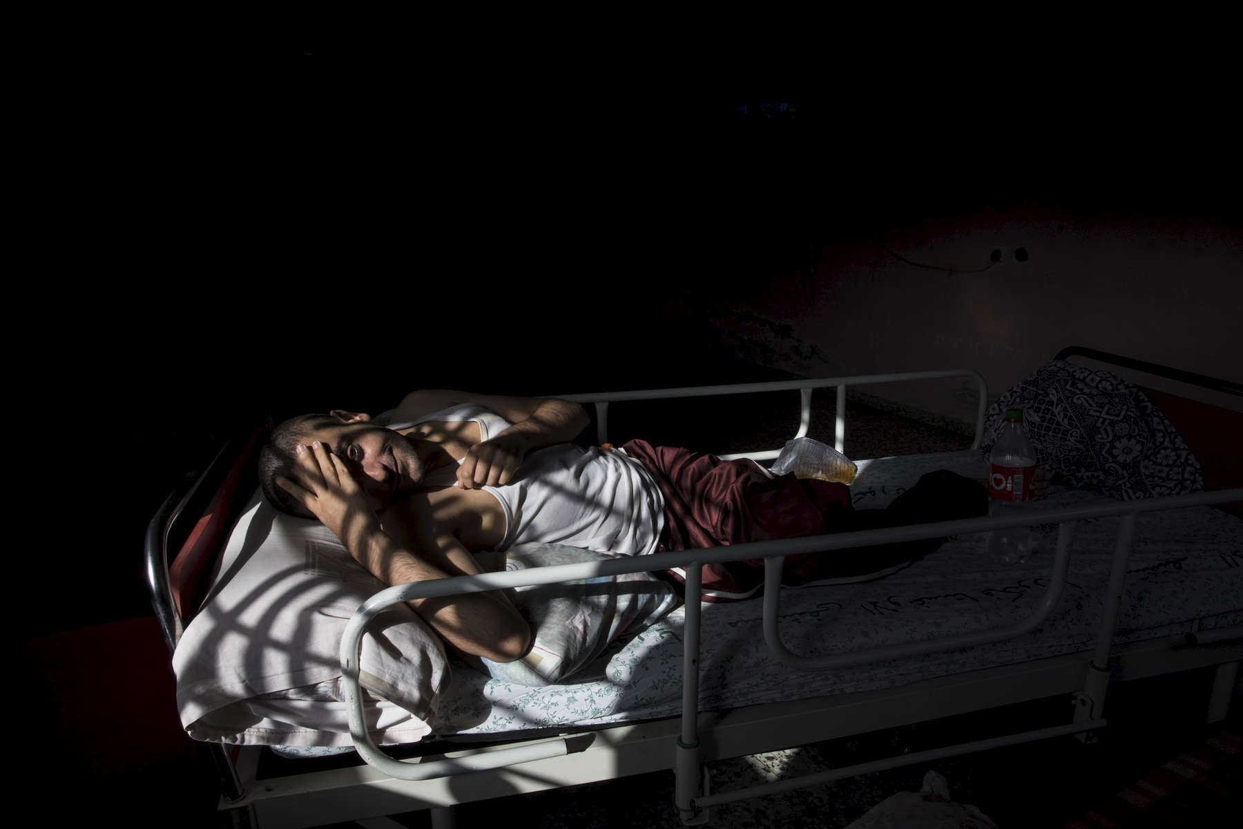 JABALIA, GAZA STRIP- MAY 26,2018 on May 26,2018 in the Gaza strip. Odai Imad Ali, 24, from Jabalia, lost hearing since he was an eight-month baby after suffering meningitis. In 2014, he got injured in his back in a bombing targeted their home's farm led to suffering hemiplegia. He suffers from severe bed sores. Everyone is well aware that Gaza's two million inhabitants are trapped in a cycle of violence and poverty, created by policies and political decisions on both sides. The problems and complications affecting Gaza today are overwhelming. The world, seemingly accustomed to the suffering of the Gazan people turns a blind eye. (Photo by Paula Bronstein ) 