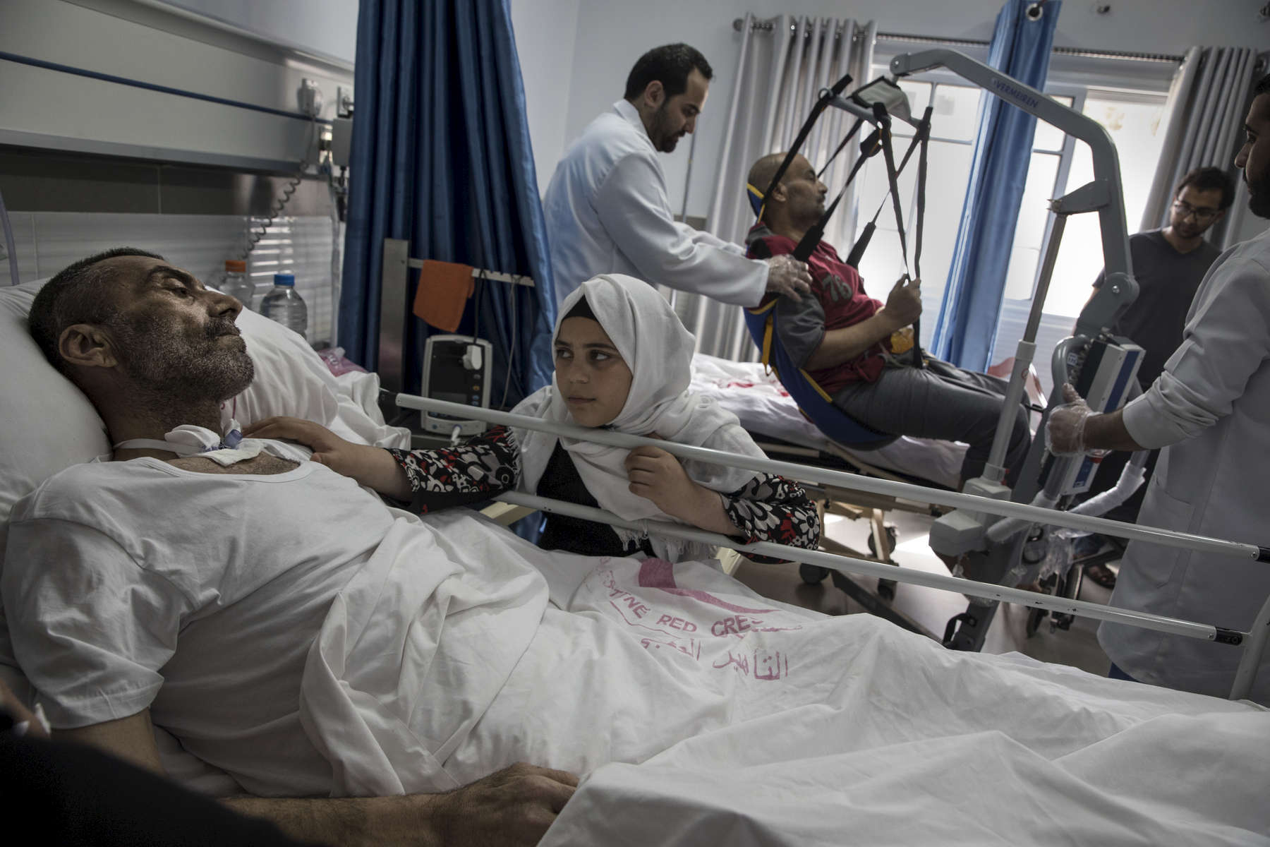  GAZA STRIP- MAY 19,2018 : Rashad Al-Baba, 58, shot twice by Israeli forces is seen with his grand daughter Lujain Al-Baba, 12, at the Red Crescent Rehabilitation Center of Al-Amal on May 19,2018 in Gaza strip. He was injured on March 30th when he arrived to the protest near Rafah looking to protect his grand children who went there without his knowledge. After the injury, Rashad suffered a heart attack, spending 27 days in the intensive care unit. The problems and complications affecting Gaza today are overwhelming. The world, seemingly accustomed to the suffering of the Gazan people turns a blind eye. (Photo by Paula Bronstein ) 