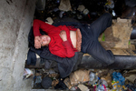 ULAAN BAATAR, MONGOLIA-MARCH 13 : Erdenetsetseg,36, rests on a water pipe, used as her bed living in a sewer filled with garbage  March 13 2010  in Ulaan Baatar, Mongolia. Erdenetsetseg moved to the capitol city from a province five years ago, without work she collects cans and bottles to make enough money to buy a little food and her daily fix of vodka.  Since 70 years of communist rule ended in 1990, Mongolia has become one of the most pro-business countries. While economic reforms have brought prosperity to Ulaan Baatar, there still widespread unemployment, some used to work in the now defunct state industries. Approximately over 35% of Mongolians live below the poverty line, many unable to buy basic food needed to survive. Social problems include depression, alcohol abuse, domestic violence and crime. Mongolia suffers with a very high number of alcoholics, all consuming cheap Mongolian vodka that is readily available to the poor and the unemployed, Many Mongolians have immigrated to the capitol city from the far away provinces seeking employment.  For the homeless during the winter this means extreme hardship, for some homeless living in the sewers means warmth verses dealing with temperatures dropping as low as -25C mid- Winter. This year Mongolia has experienced the worst winter in 30 years. (Photo by Paula Bronstein /Getty Images)