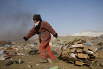 ULAAN BAATAR, MONGOLIA-MARCH 5 :  A Mongolian woman drags cardboard to the truck working collecting and recycling the garbage at a dump March 5, 2010  in Ulaan Baatar, Mongolia. Working at the garbage dump means extreme hardship, long hours outside in frigid temperatures dropping below -25C in the Winter as Mongolia experienced one of the worst Winter in 30 years. Presently the government has declared an emergency requiring foreign aid to alleviate the impact of the {quote} Zud{quote} ( Mongolian term for a multiple natural disaster) caused by bitter cold and thick snow. Currently 1.5 million goats,  921,000 sheep, 169,000 cows and yaks, 89,000 horses and 1,500 camels had died according to the various UN agency reports. Many Mongolians have immigrated to the capitol city from the far away provinces seeking employment, living in rented traditional circular felt yurts with no running water or electricity.(Photo by Paula Bronstein /Getty Images)