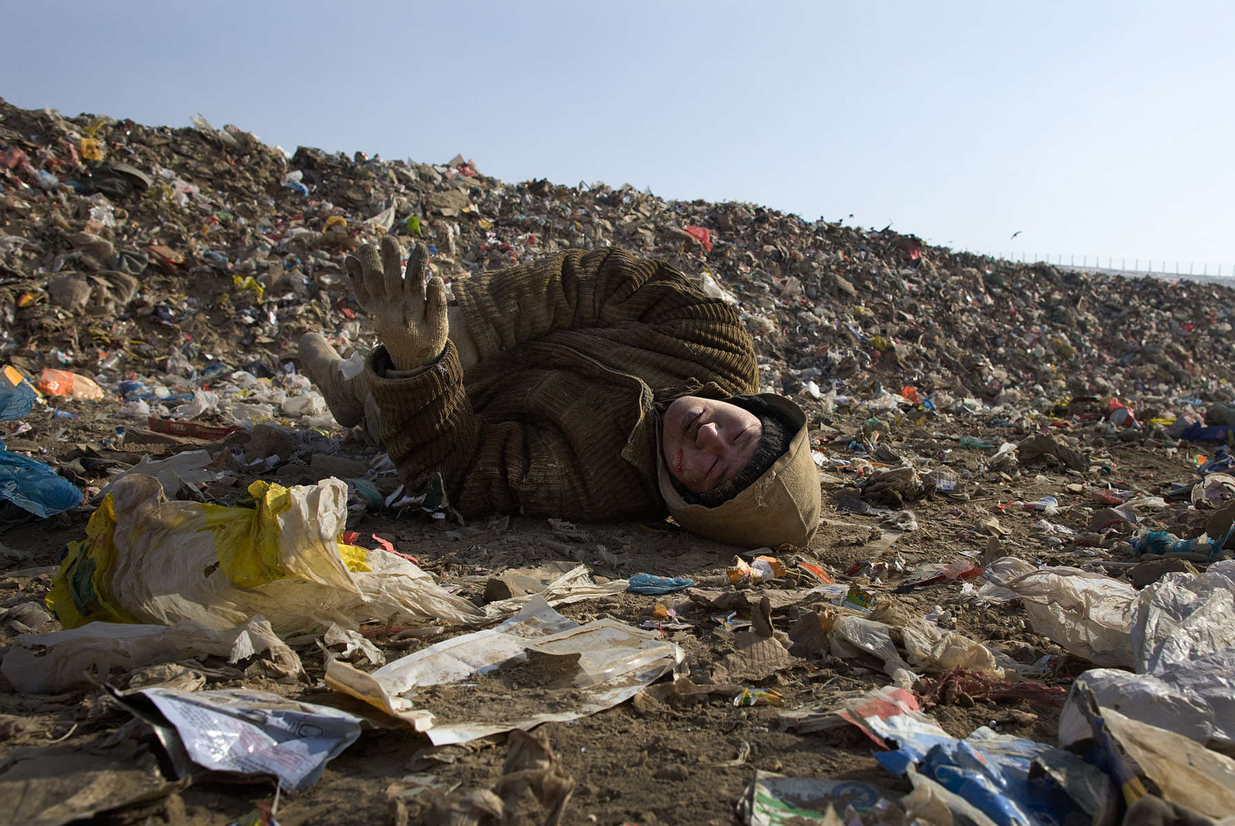ULAAN BAATAR, MONGOLIA-MARCH 5 :  Turu, a Mongolian worker collapses after having a serious seizure while working collecting and recycling the garbage at a dump March 5, 2010  in Ulaan Baatar, Mongolia. Working at the garbage dump means extreme hardship, long hours outside in frigid temperatures dropping below -25C in the Winter as Mongolia experienced one of the worst Winter in 30 years. Presently the government has declared an emergency requiring foreign aid to alleviate the impact of the {quote} Zud{quote} ( Mongolian term for a multiple natural disaster) caused by bitter cold and thick snow. Currently 1.5 million goats,  921,000 sheep, 169,000 cows and yaks, 89,000 horses and 1,500 camels had died according to the various UN agency reports. Many Mongolians have immigrated to the capitol city from the far away provinces seeking employment, living in rented traditional circular felt yurts with no running water or electricity.(Photo by Paula Bronstein /Getty Images)