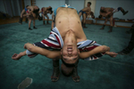 Mongolian wrestlers go through warm up exercises at a local wrestling school in Ulan Batar. Mongolia is the most sparsely populated country on earth, but its people are some of the strongest. In Mongolia, wrestling is the most important sport that runs deep into its culture along with horsemanship and archery. Going back for hundreds of years, history books tell the story of how Genghis Khan considered wrestling to be an important way to keep his army combat ready while back in the Qing Dynasty (1646–1911) regular wrestling events were held. In Mongolia’s capitol city, Ulan Batar is home to many wrestling schools where almost daily you can see dozens of young men sweating in crowded gyms while in schools both girls and boys are taught some wrestling techniques.While my photo story gives a real behind the scenes look, it is unusual for a woman to document this macho scene of sweat and endurance.