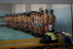 Mongolian wrestlers stand at attention before starting their practice at a local wrestling school. Mongolia is the most sparsely populated country on earth, but its people are some of the strongest. In Mongolia, wrestling is the most important sport that runs deep into its culture along with horsemanship and archery. Going back for hundreds of years, history books tell the story of how Genghis Khan considered wrestling to be an important way to keep his army combat ready while back in the Qing Dynasty (1646–1911) regular wrestling events were held. In Mongolia’s capitol city, Ulan Batar is home to many wrestling schools where almost daily you can see dozens of young men sweating in crowded gyms while in schools both girls and boys are taught some wrestling techniques.While my photo story gives a real behind the scenes look, it is unusual for a woman to document this macho scene of sweat and endurance.