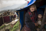 BARPAK, NEPAL -MAY 1, 2015:. Dhan Maya Ghale,68 holds her grandson, Sujal,3, hiding from the rain in a temporary shelter in Barpak where 60% of the village has been destroyed. The village is amongst the largest in Gorkha province with a population of around 10-12,000. Around 57-60 died. So far almost 6,000 people have died in Nepal\'s worst earthquake in 80 years.  (Photo by Paula Bronstein/ for the Wall Street Journal)