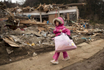  Neena Sasaki, 5, carries some of the family belongings from her home that was destroyed after the devastating earthquake and tsunami March 15, 2011 in Rikuzentakata,  Miyagi province, Japan.  One of the world\'s most developed country suffered it\'s worst natural disaster as a strong 8.9 earthquake followed by a Tsunami hit the north-central coast of Japan, killing thousands, followed by a potential nuclear meltdown after the country\'s major nuclear plant was seriously damaged from the quake. 