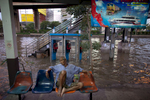 BANGKOK,THAILAND - NOVEMBER 2 : A Thai man sits at a flooded train station in the Laksi area  November 2, 2011 in Bangkok, Thailand. Thousands of flood victims have been forced to take shelter at crowded evacuation centers around the capitol city. Hundreds of factories have been closed in the central Thai province of Ayutthaya and Nonthaburi and millions of tons of rice has been damaged. Thailand is experiencing the worst flooding in over 50 years which has affected more than nine million people. Over 400 people have died in flood-related incidents since late July according to the Department of Disaster Prevention and Mitigation.(Photo by Paula Bronstein /Getty Images)