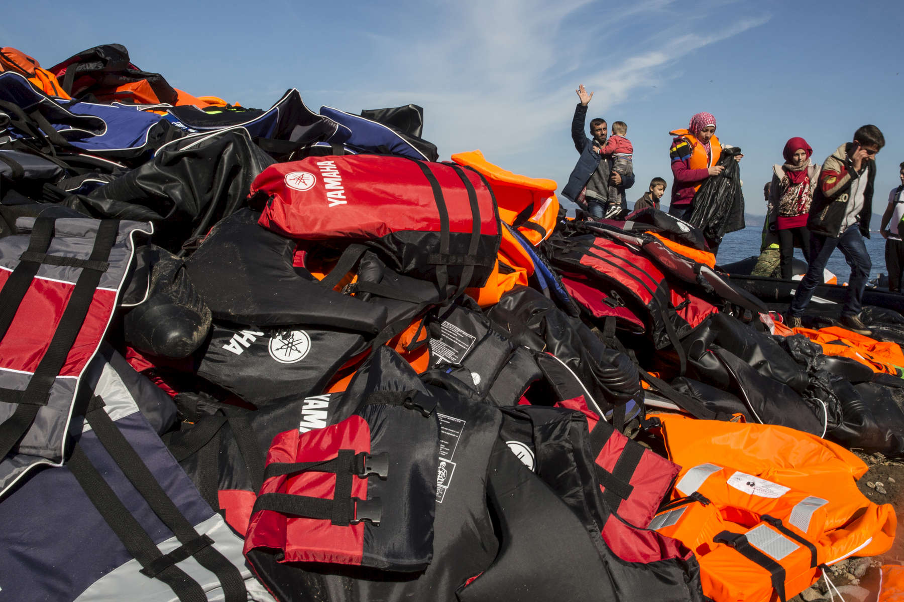 LESBOS, GREECE - OCTOBER 26: Lifejackets are seen everywhere another raft lands filled with more refugees from Turkey. Colder weather and rough seas continue to cause deaths at sea as thousands travel in overcrowded small rafts. According to the IOM, an estimated 100,000 people landed in Greece, an average of almost 4,500 per day in late October and November. Nearly all of those entering Greece on a boat from Turkey are from the war zones of Syria, Iraq and Afghanistan. (Photo by Paula Bronstein)